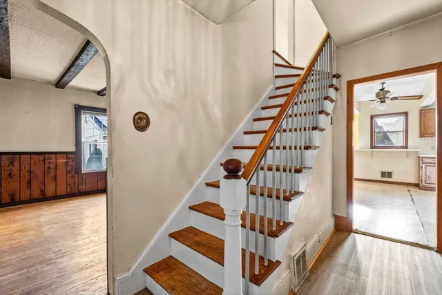 a view of front door with wooden floor and stairs