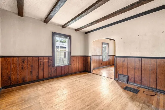 a view of an empty room with wooden floor