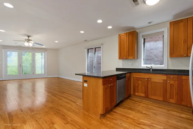 a kitchen with stainless steel appliances granite countertop a sink and wooden floor