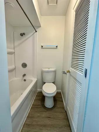a bathroom with a granite countertop sink toilet and mirror