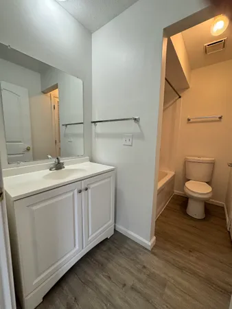 a view of a house with wooden fence next to a yard