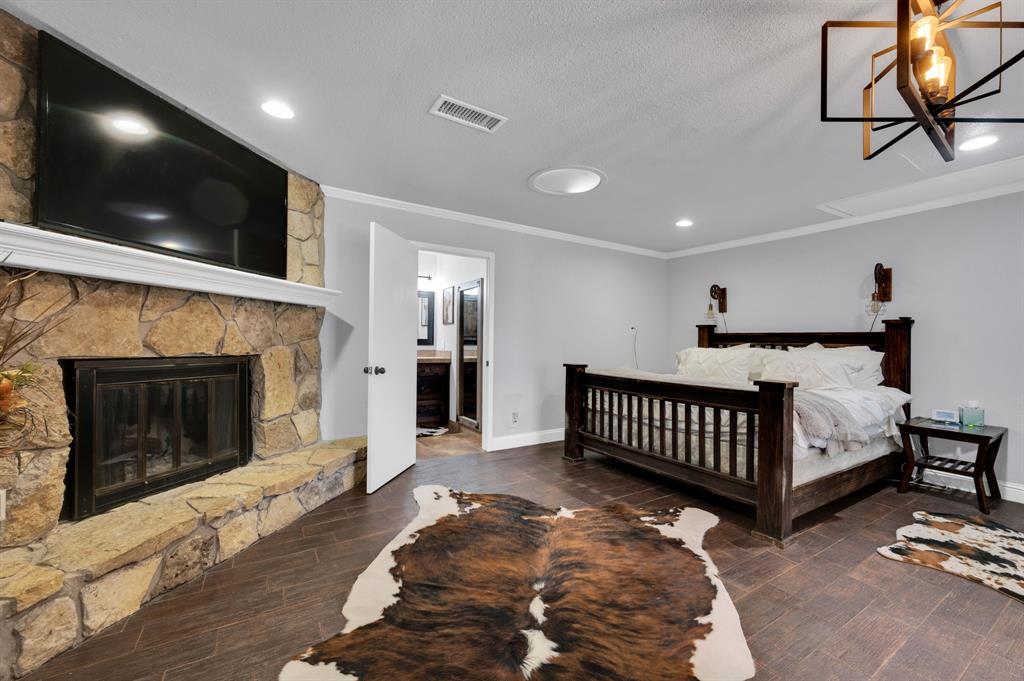 2263 Old Dicey Road Weatherford, TX 76085 - Photo 13 of 40 a spacious bedroom with a bed and a fireplace