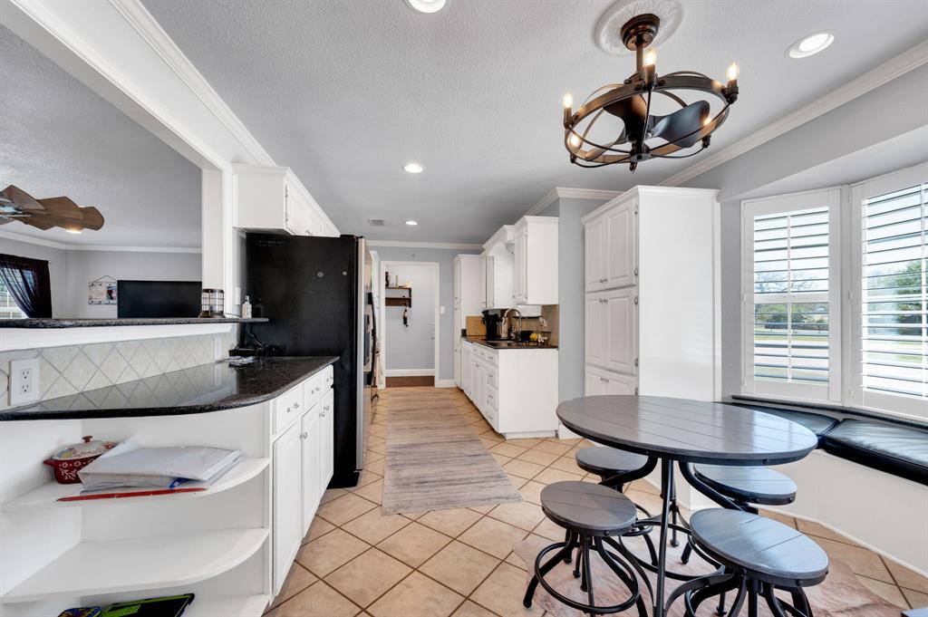 2263 Old Dicey Road Weatherford, TX 76085 - Photo 7 of 40 a kitchen with stainless steel appliances kitchen island granite countertop a sink a refrigerator and chairs