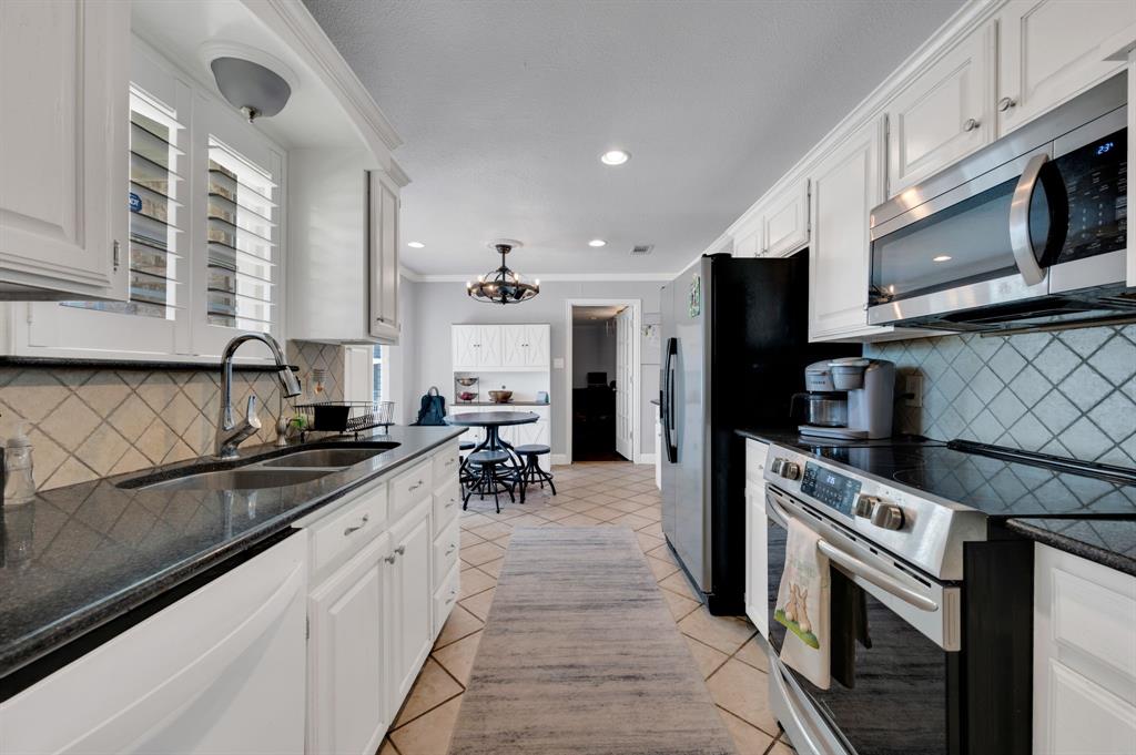 2263 Old Dicey Road Weatherford, TX 76085 - Photo 9 of 40 a kitchen with stainless steel appliances granite countertop a sink and a stove