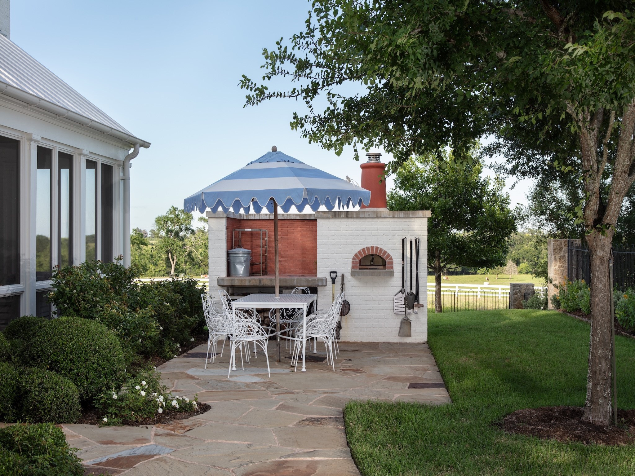 2228 Center Hill Road Bellville, TX 77418 - Photo 19 of 50 View of the wood-burning pizza oven and patio area between the screened-in porch and pool.
