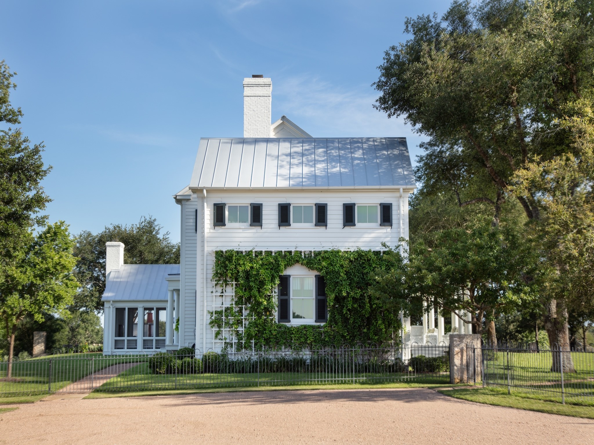 2228 Center Hill Road Bellville, TX 77418 - Photo 5 of 50 Side view of the main house featuring a screened porch to the left overlooking the pool and pasture, with a covered porch on the opposite side facing the guest house.
