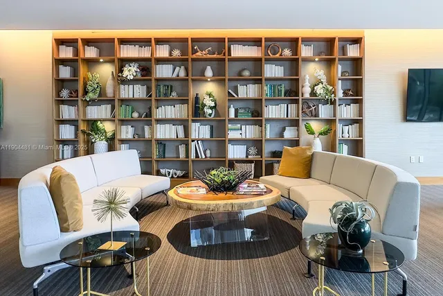 a living room with furniture a rug and a book shelf
