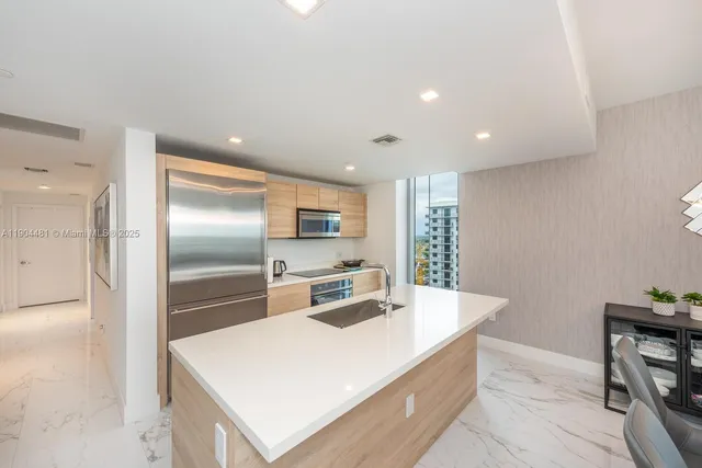 a kitchen with stainless steel appliances a sink and a refrigerator