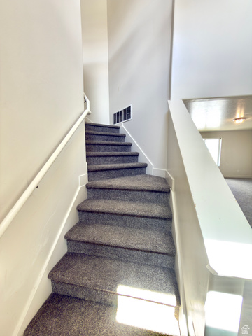 1823 South Longview Road Santaquin, UT 84655 - Photo 27 of 69 Carpeted staircase with white handrail and neutral wall tones