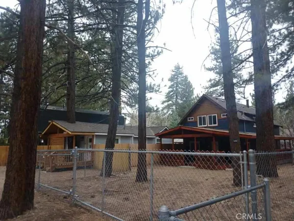 a view of house with a yard in the background