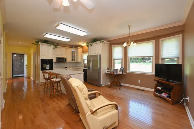 a living room with furniture a flat screen tv and wooden floor