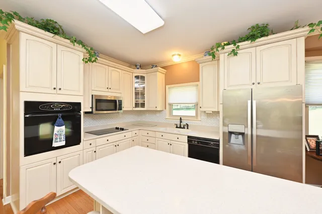 a kitchen with granite countertop a refrigerator stove top oven and sink