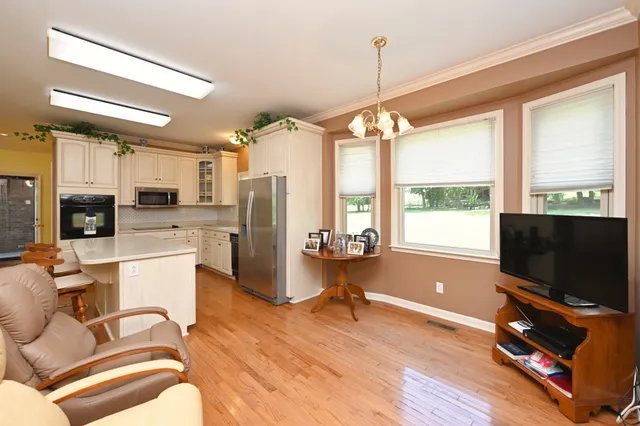 a living room with furniture a flat screen tv and a large window