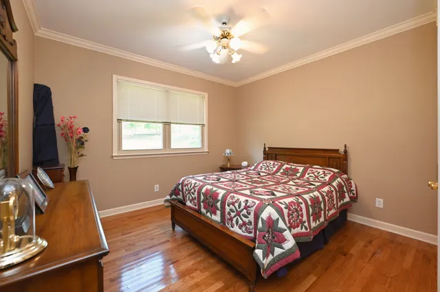 a bedroom with a bed flat screen tv and a window