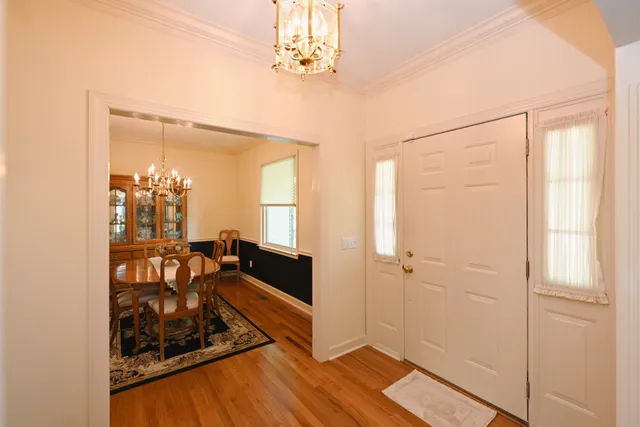 a view of a livingroom with wooden floor and a chandelier