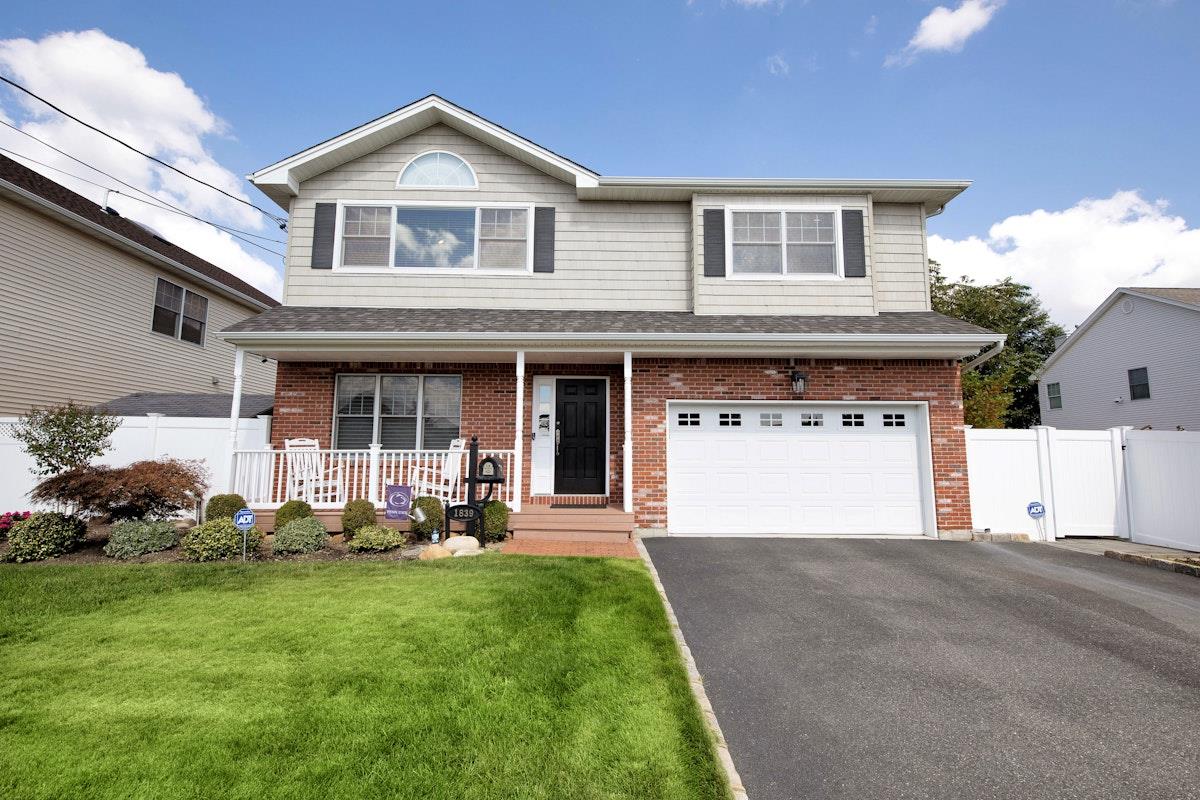 1839 Henry Road Merrick, NY 11566 - Photo 1 of 1 a front view of a house with a yard and garage
