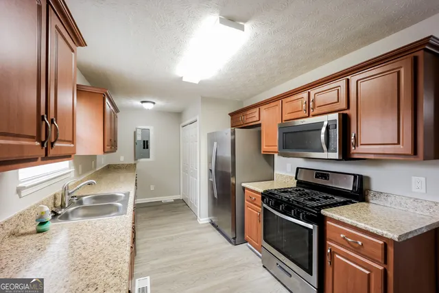 a kitchen with stainless steel appliances granite countertop a stove a sink and a refrigerator