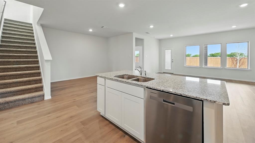 1608 Basalt Lane Celina, TX 75009 - Photo 21 of 36 a view of a kitchen with a sink and dishwasher with wooden floor