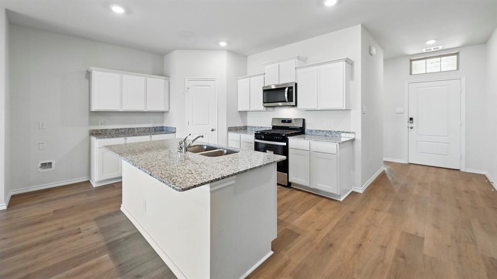 1608 Basalt Lane Celina, TX 75009 - Photo 28 of 36 a kitchen with granite countertop a sink stove and refrigerator