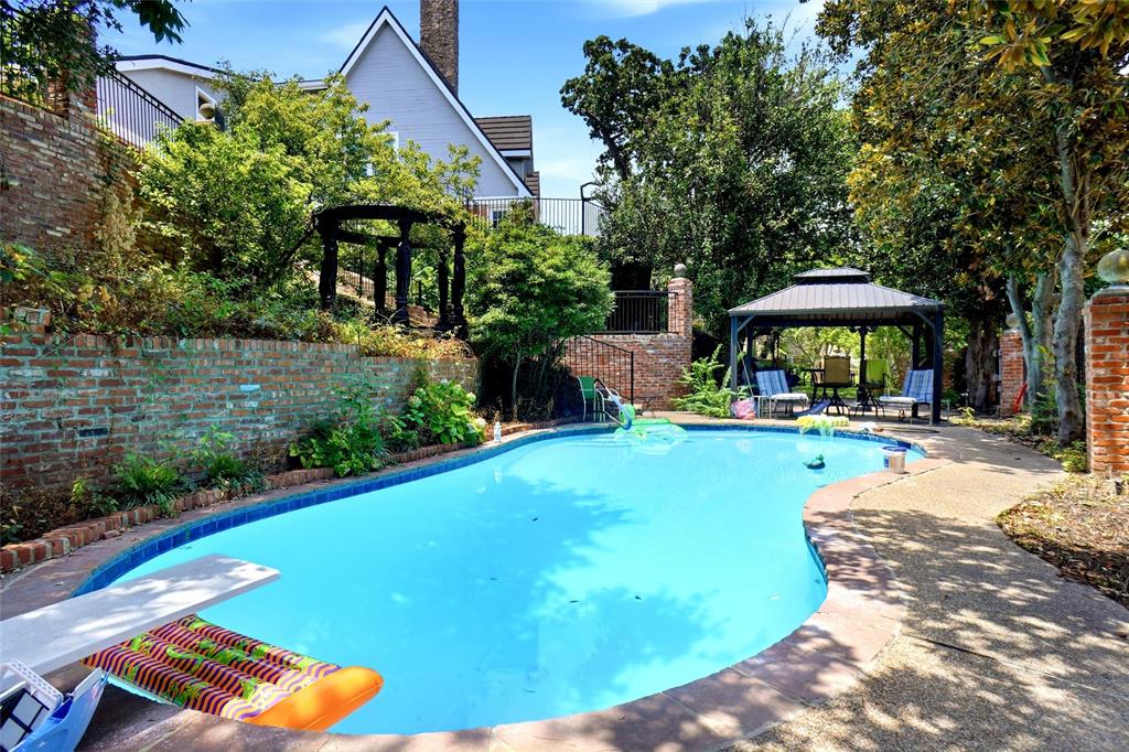 2011 Ridgemont Court Arlington, TX 76012 - Photo 1 of 40 a view of a swimming pool with lawn chairs under an umbrella