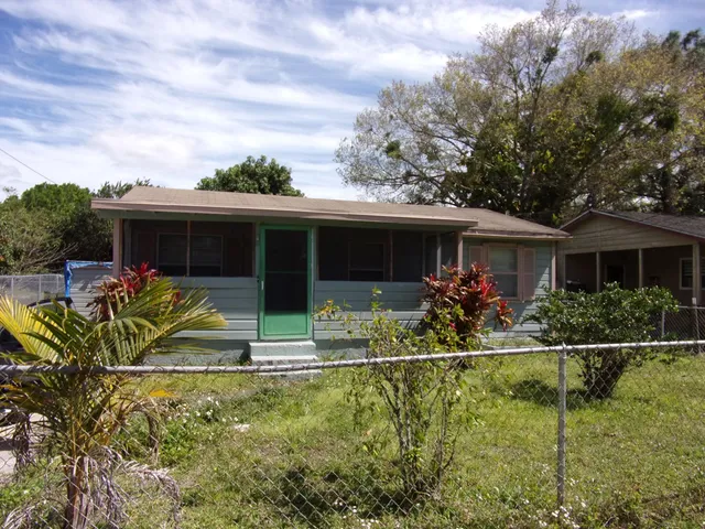 a view of house with swimming pool and outdoor seating