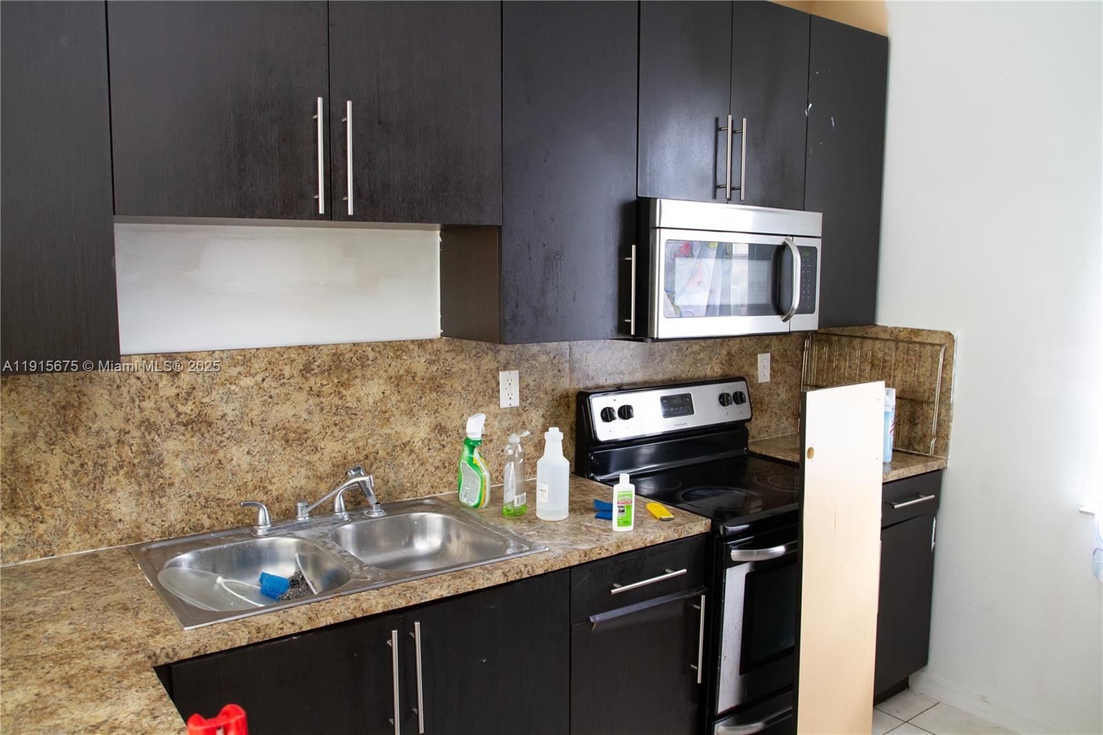 761 Southeast 2nd Street, Unit 761 Homestead, FL 33030 - Photo 2 of 12 a kitchen with a sink and a stove