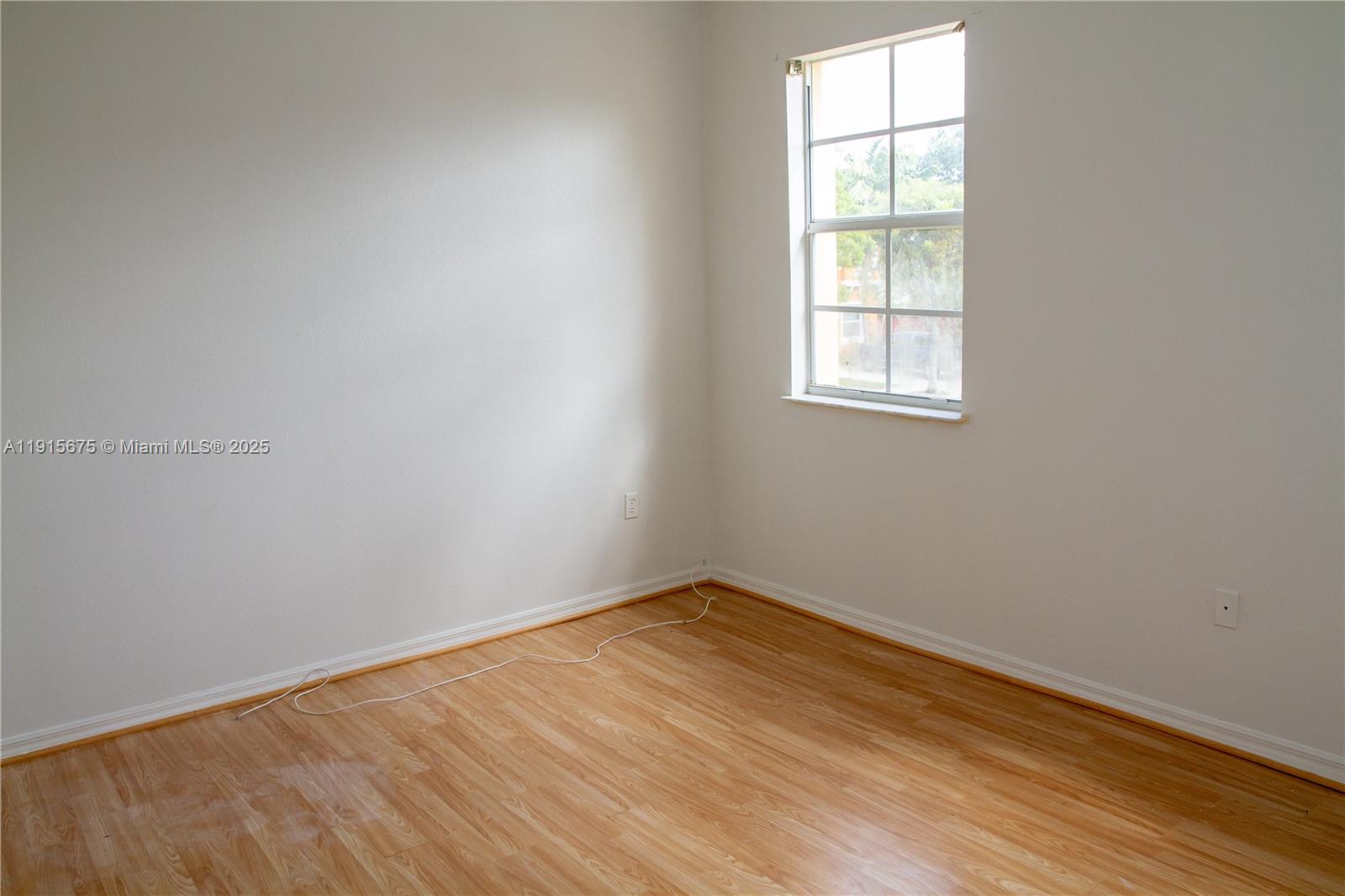 761 Southeast 2nd Street, Unit 761 Homestead, FL 33030 - Photo 7 of 12 an empty room with wooden floor and windows