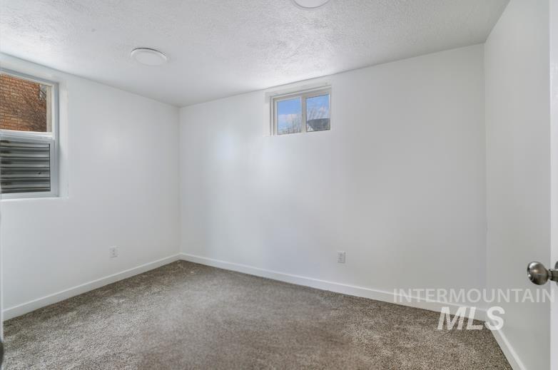 201 East 27th Street Burley, ID 83318 - Photo 13 of 19 Carpeted spare room featuring a textured ceiling and baseboards