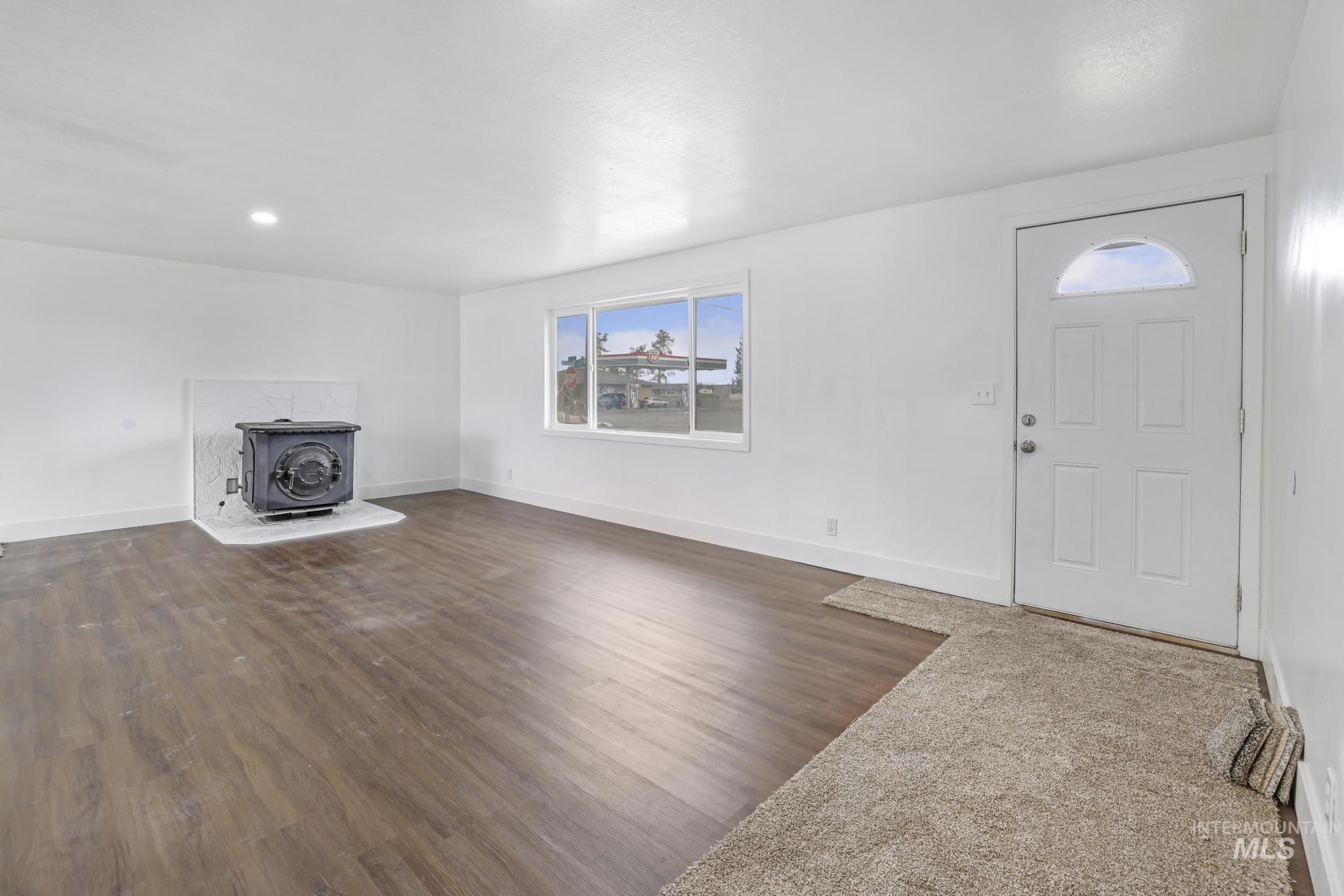 201 East 27th Street Burley, ID 83318 - Photo 2 of 19 Unfurnished living room with a wood stove, dark wood-style floors, and recessed lighting