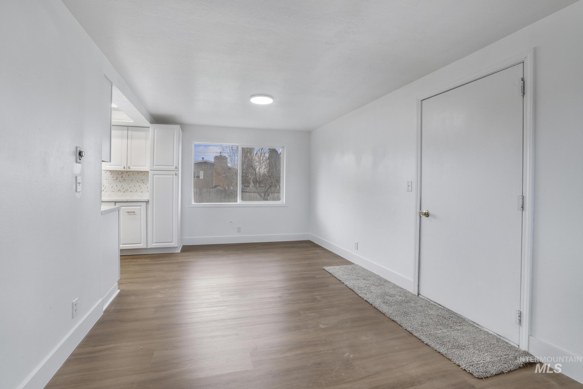 201 East 27th Street Burley, ID 83318 - Photo 3 of 19 Unfurnished living room with dark wood-style flooring and baseboards