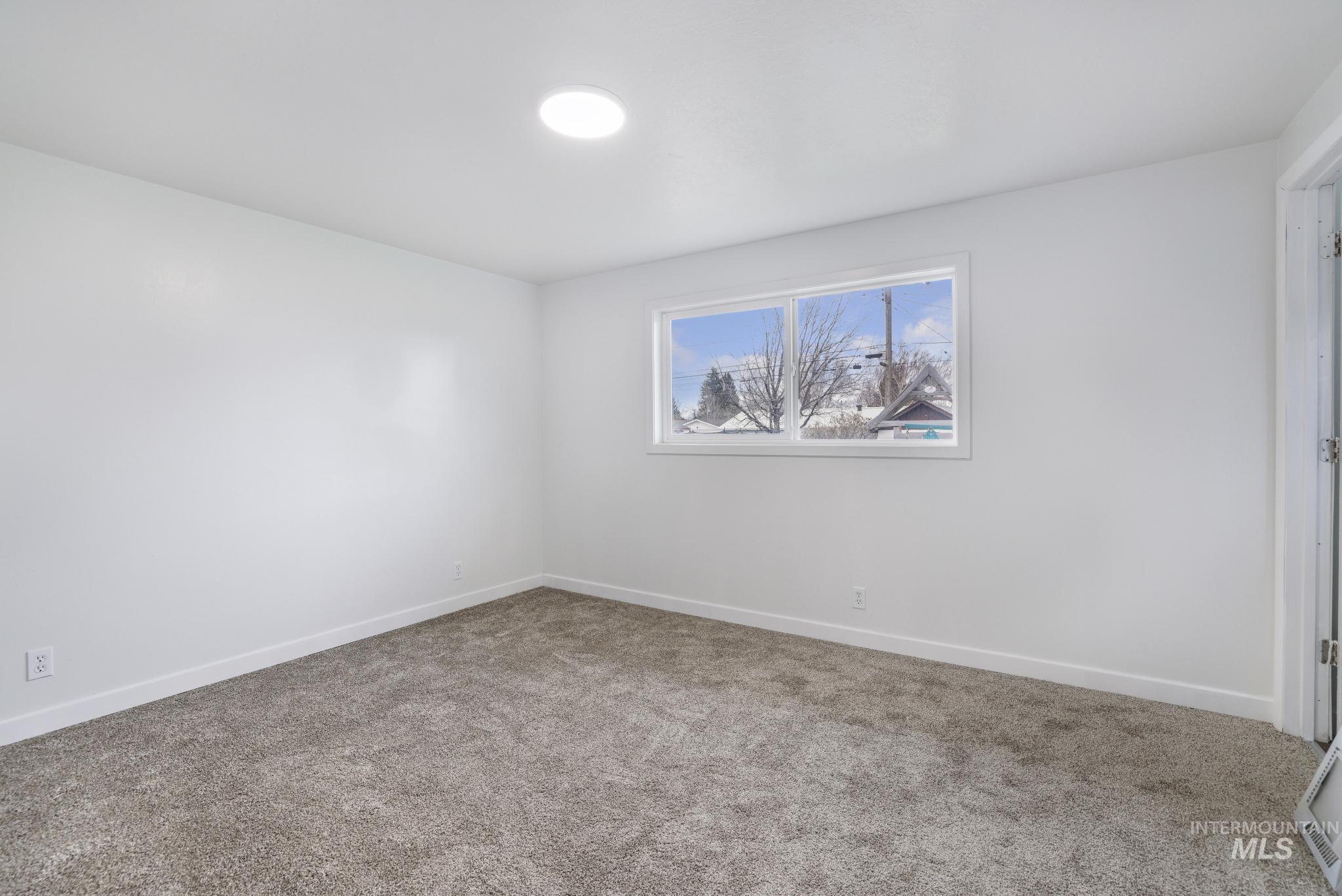 201 East 27th Street Burley, ID 83318 - Photo 6 of 19 Unfurnished room with light carpet and baseboards