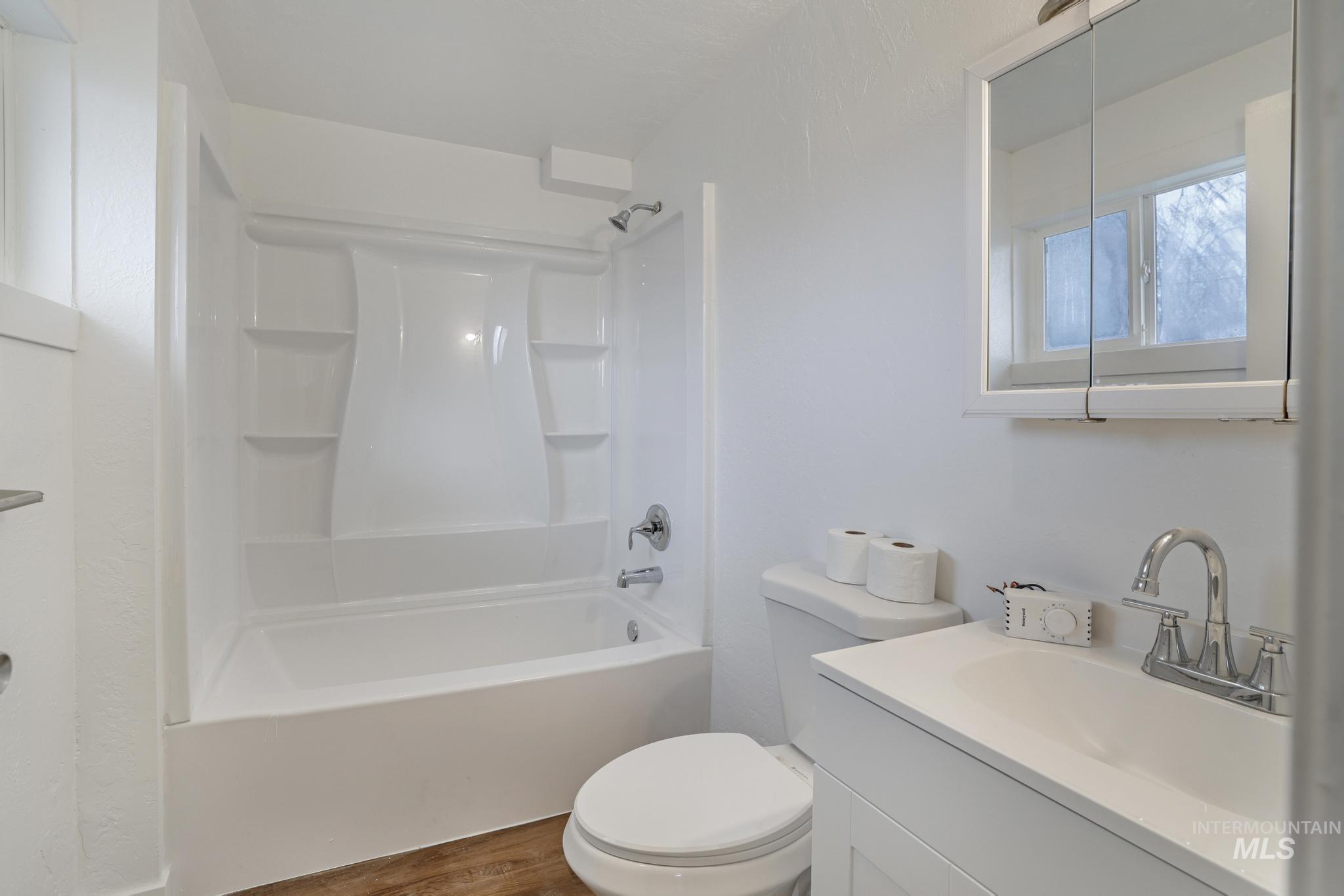 201 East 27th Street Burley, ID 83318 - Photo 9 of 19 Bathroom featuring vanity, bathing tub / shower combination, and wood finished floors