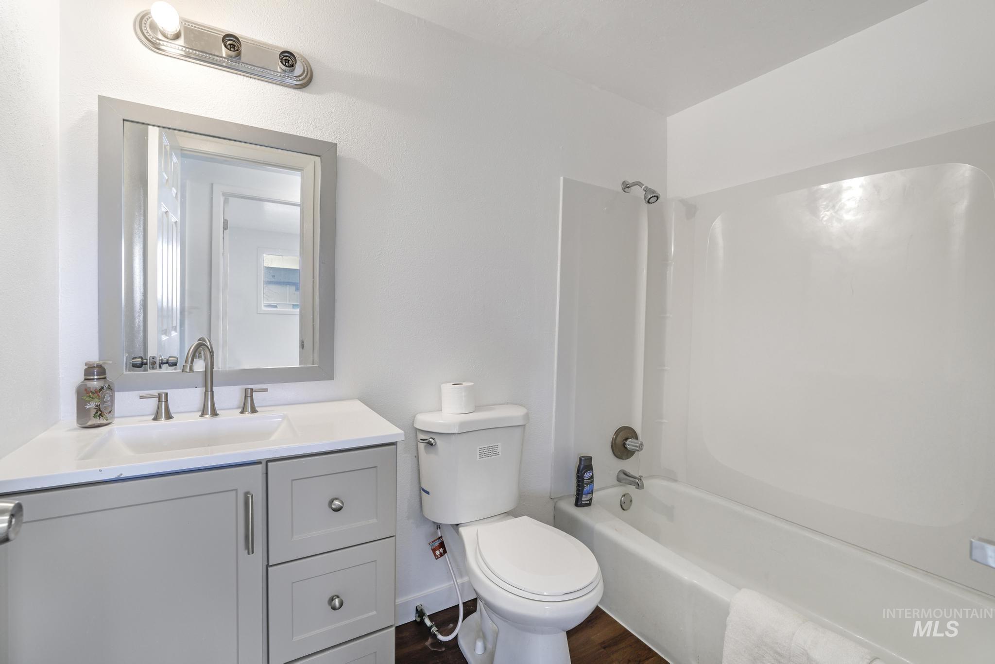 201 East 27th Street Burley, ID 83318 - Photo 10 of 19 Bathroom featuring shower / bathtub combination, vanity, and dark wood-style flooring