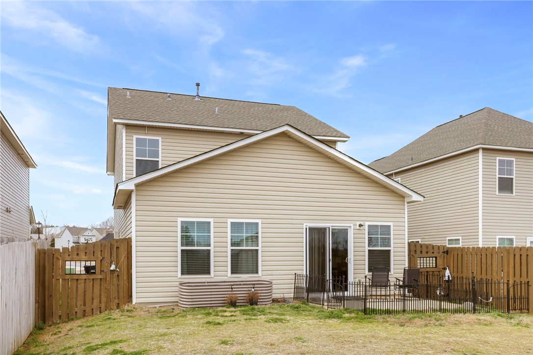 251 Samuel Street Pendleton, SC 29670 - Photo 28 of 37 This house features a compact yard with a patio area and wood fencing.