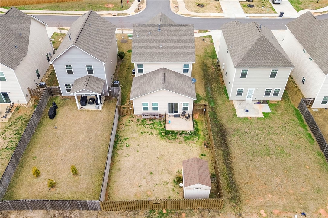 251 Samuel Street Pendleton, SC 29670 - Photo 35 of 37 An aerial perspective showcases a residential backyard with a practical shed and fenced perimeter.