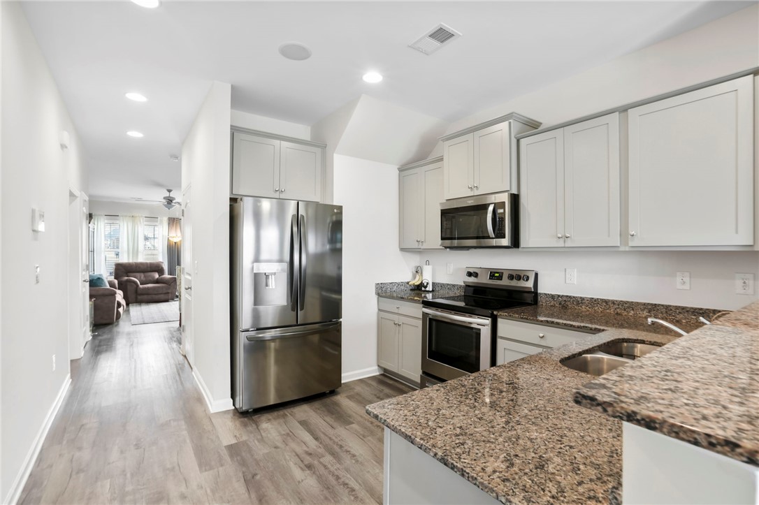 251 Samuel Street Pendleton, SC 29670 - Photo 8 of 37 This sleek kitchen features modern appliances and elegant countertops, offering seamless open-concept living.