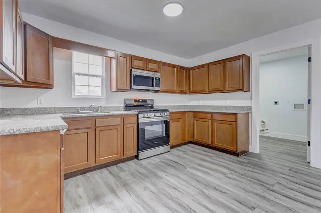 a kitchen with a sink cabinets and wooden floor