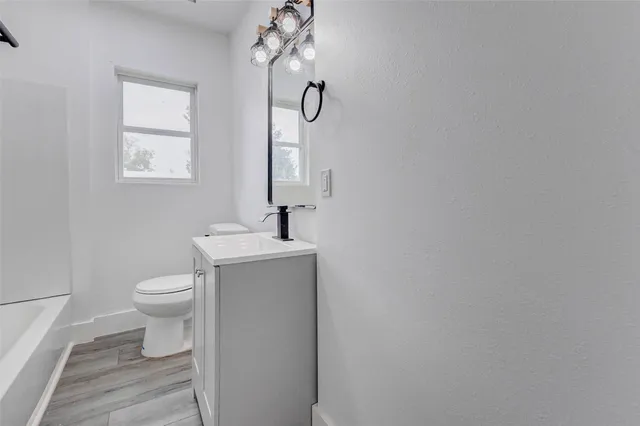 a bathroom with a toilet a sink and mirror