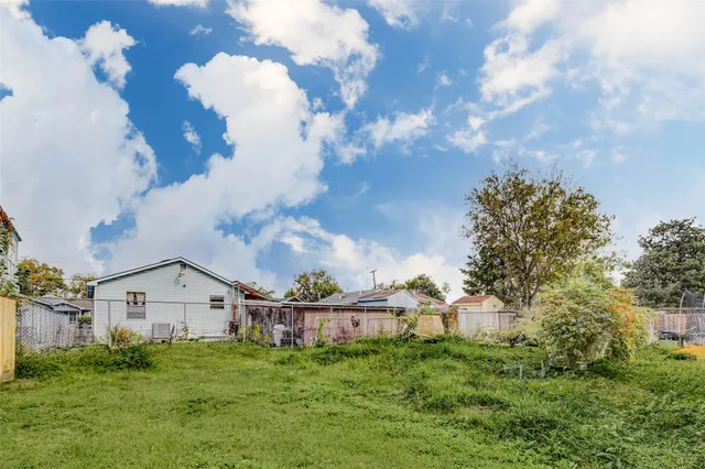 a view of a house with a big yard and large trees