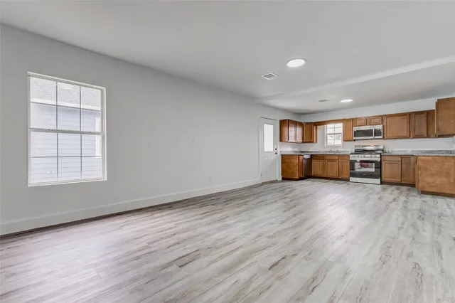 a view of a kitchen with furniture and wooden floor