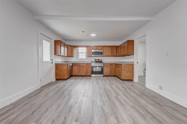 a view of kitchen with wooden floor and electronic appliances