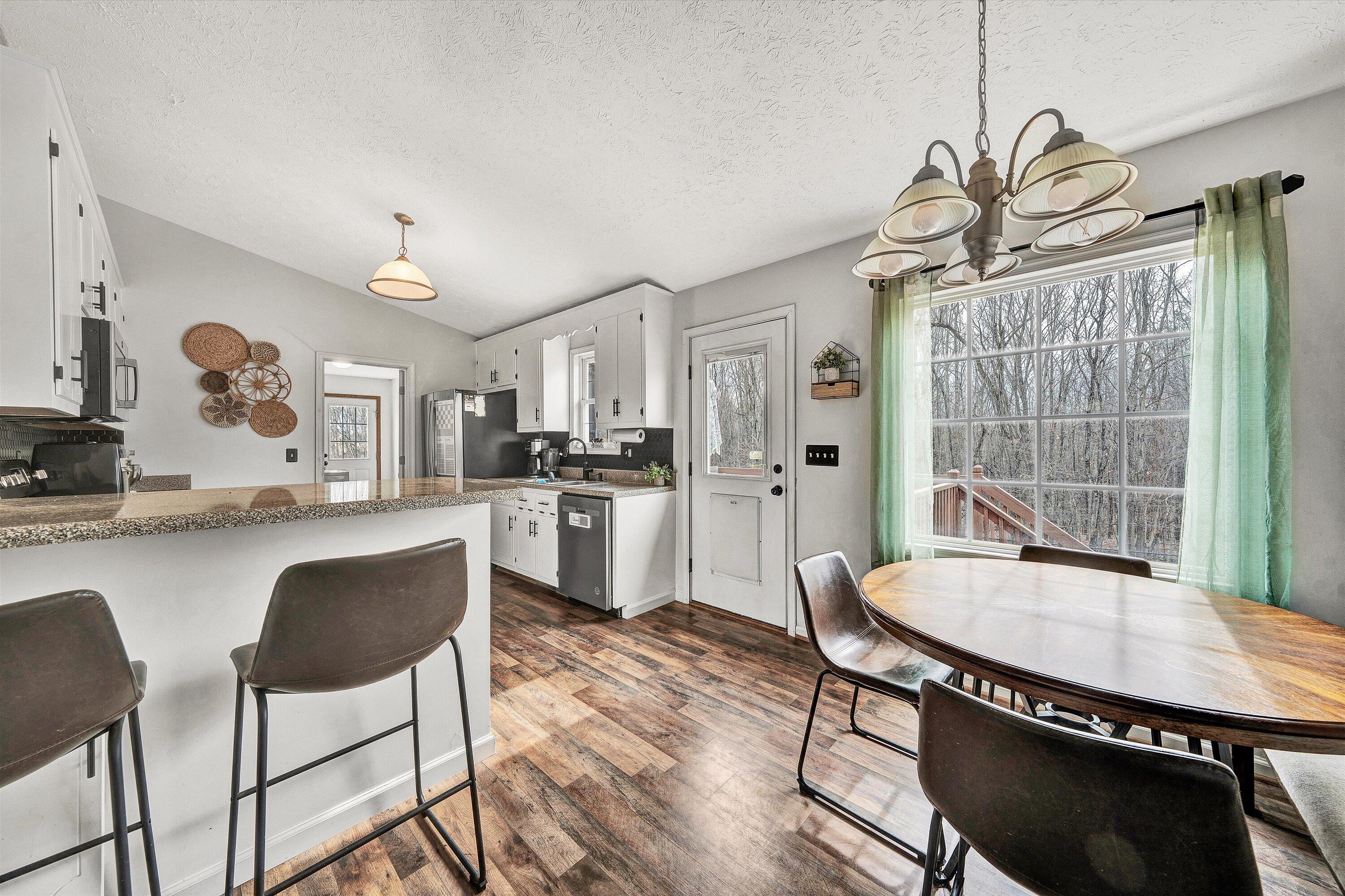 1188 Airport Road Moneta, VA 24121 - Photo 13 of 34 a kitchen with granite countertop a table chairs stove and cabinets