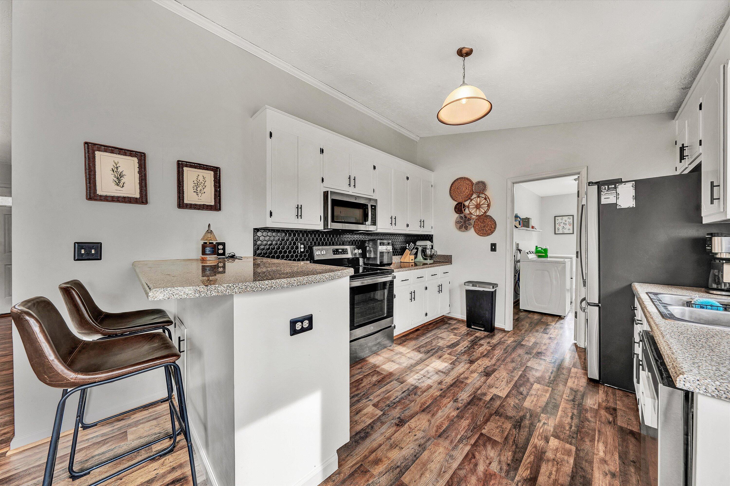 1188 Airport Road Moneta, VA 24121 - Photo 14 of 34 a kitchen with granite countertop a stove a sink a dining table and chairs