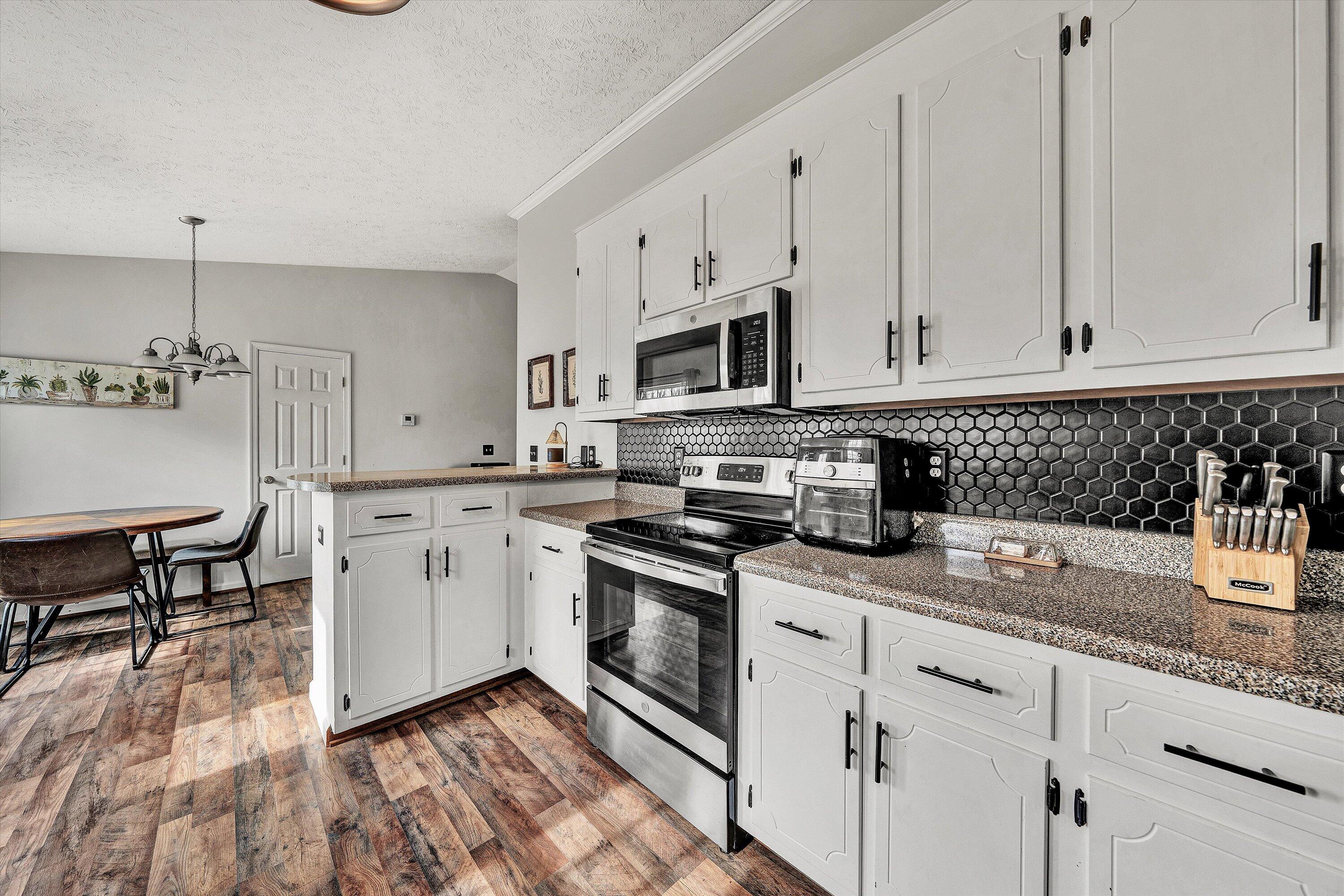 1188 Airport Road Moneta, VA 24121 - Photo 16 of 34 a kitchen with stainless steel appliances granite countertop a stove a sink and white cabinets