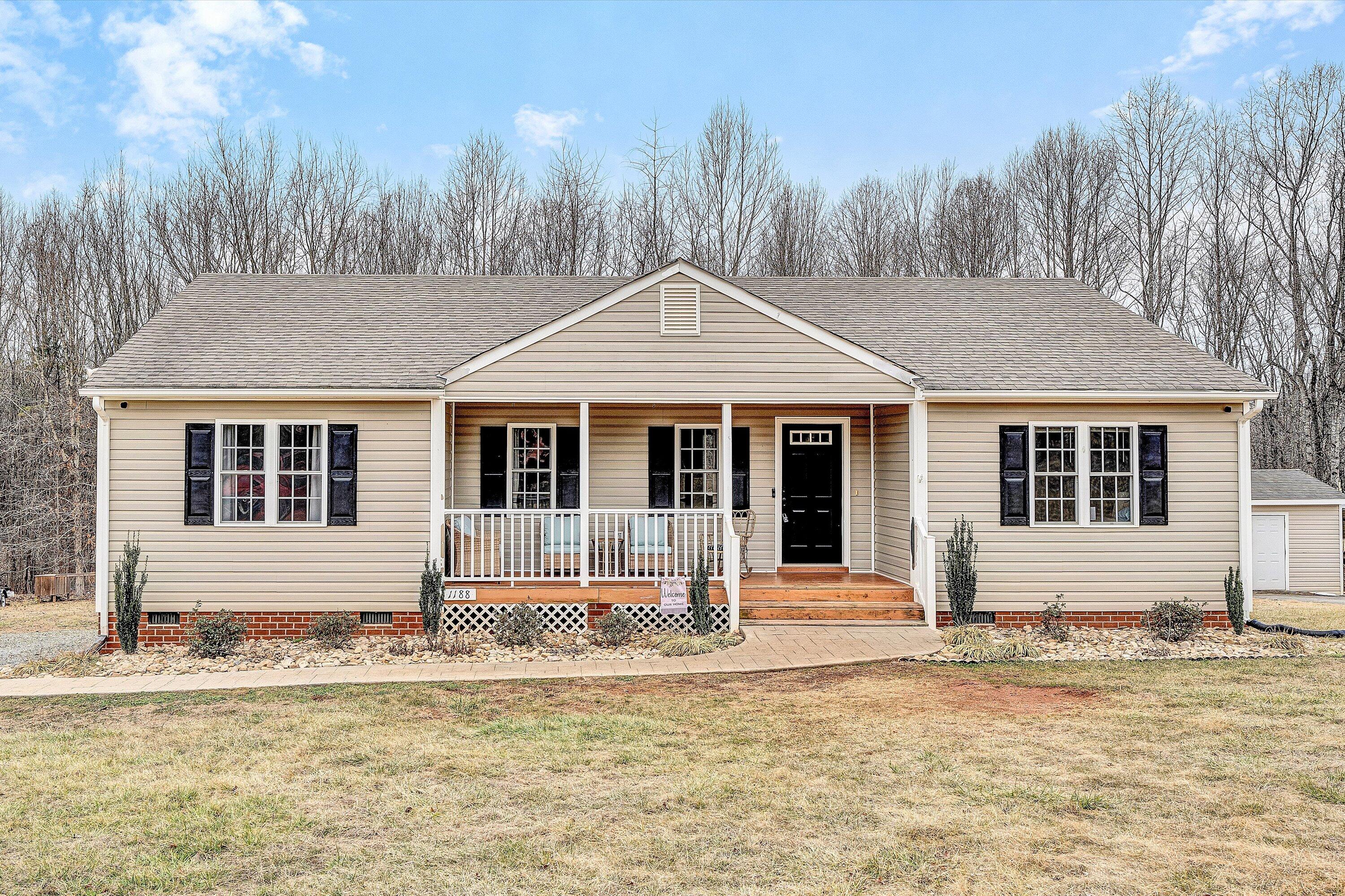 1188 Airport Road Moneta, VA 24121 - Photo 2 of 34 a front view of a house with a garden and trees