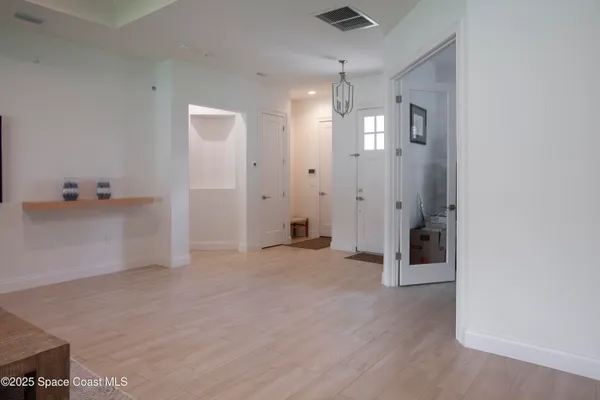 an empty room with closet and a chandelier fan