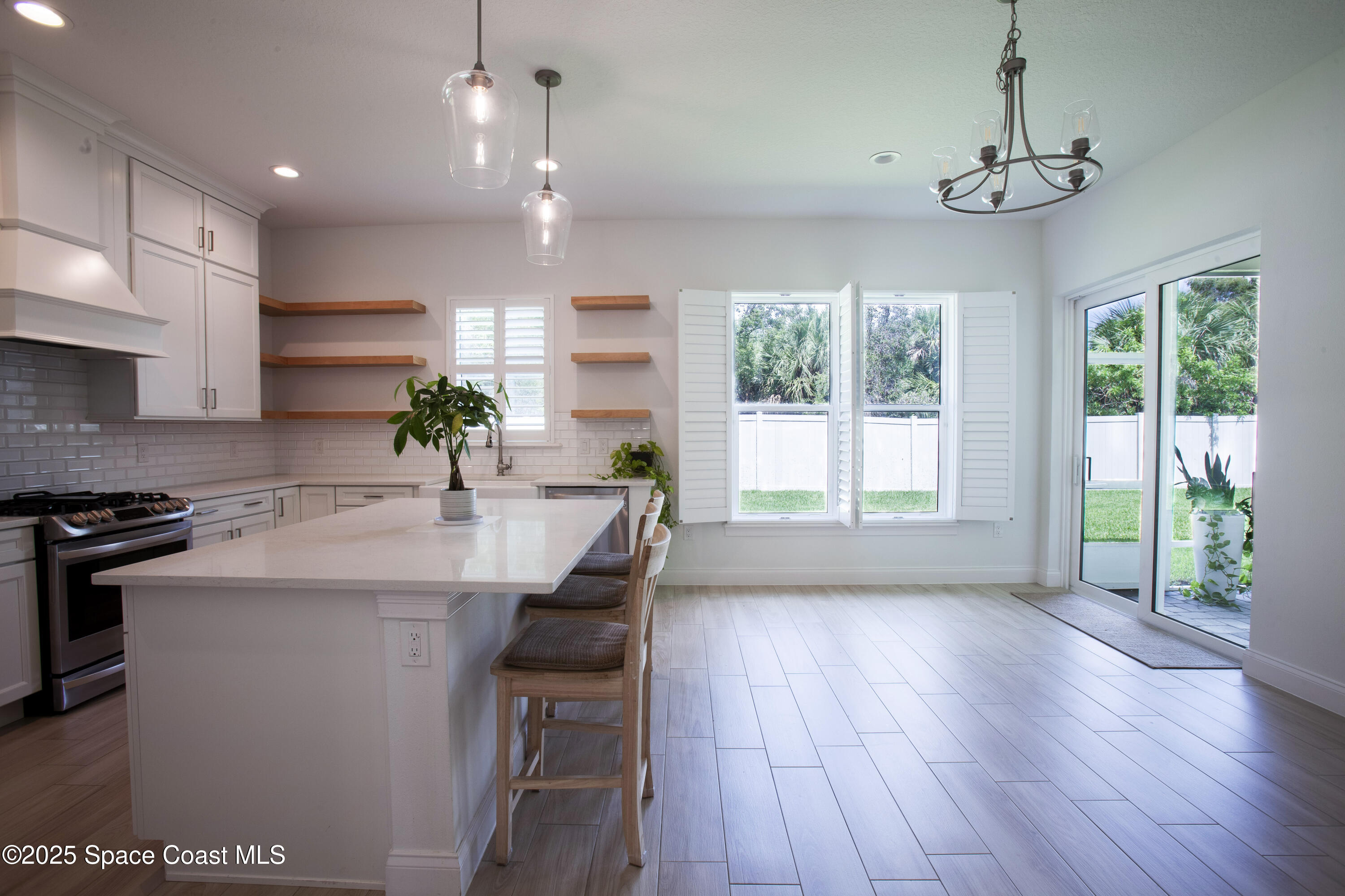 4305 Negal Circle Melbourne, FL 32901 - Photo 10 of 40 a kitchen with kitchen island granite countertop a stove a sink a center island and wooden floor
