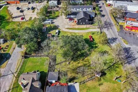 an aerial view of residential houses with outdoor space and parking