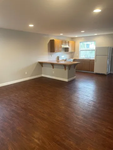 a large kitchen with stainless steel appliances granite countertop a large counter top a sink and a dishwasher