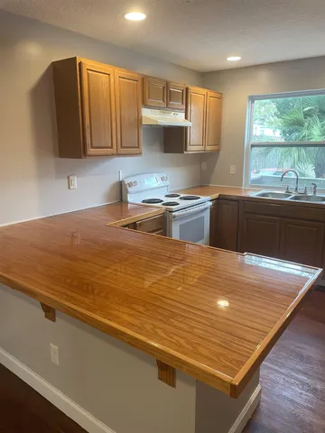 a kitchen with stainless steel appliances granite countertop a stove a sink and a microwave